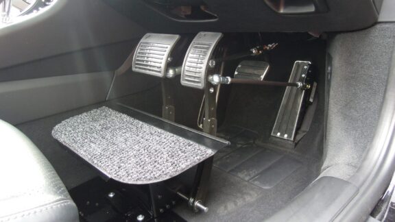 Brake and Accelerator extensions bring the pedals about a foot closer to the driver's seat, next to a raised and carpeted footrest