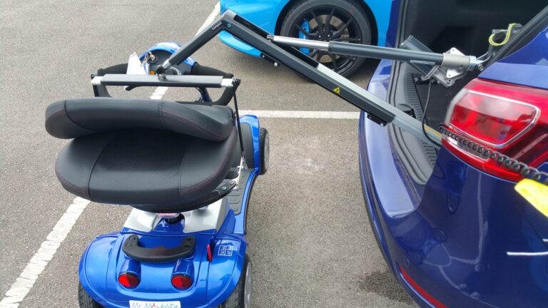 Smart Lifter LC hoist attached to a mobility scooter extended out of the open boot of a car.