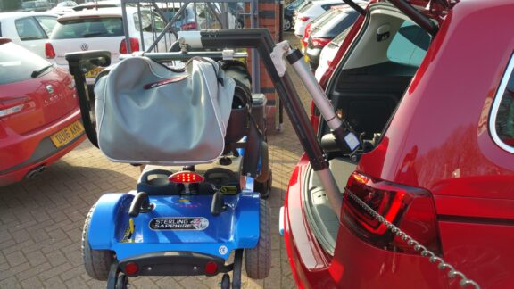 A Smart Lifter LP lifting a mobility scooter into the open boot of a car.