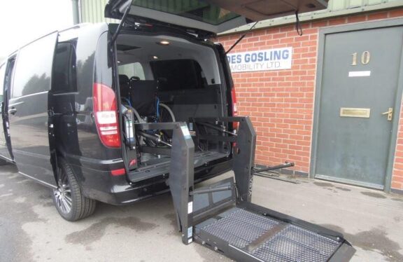 Braun Access Vista Lift installed in the rear of a van, and lowered to the ground outside the van.