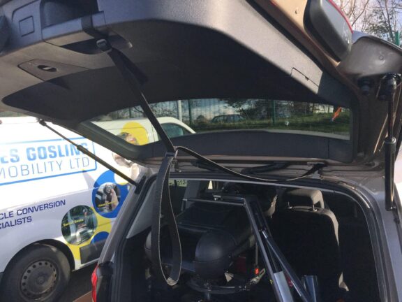 A Strap attached to an open boot door, with a loop for grabbing and pulling to close.