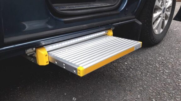 Electric Side Step is shown installed beneath the driver's car door, extended to provide a step up into the car.