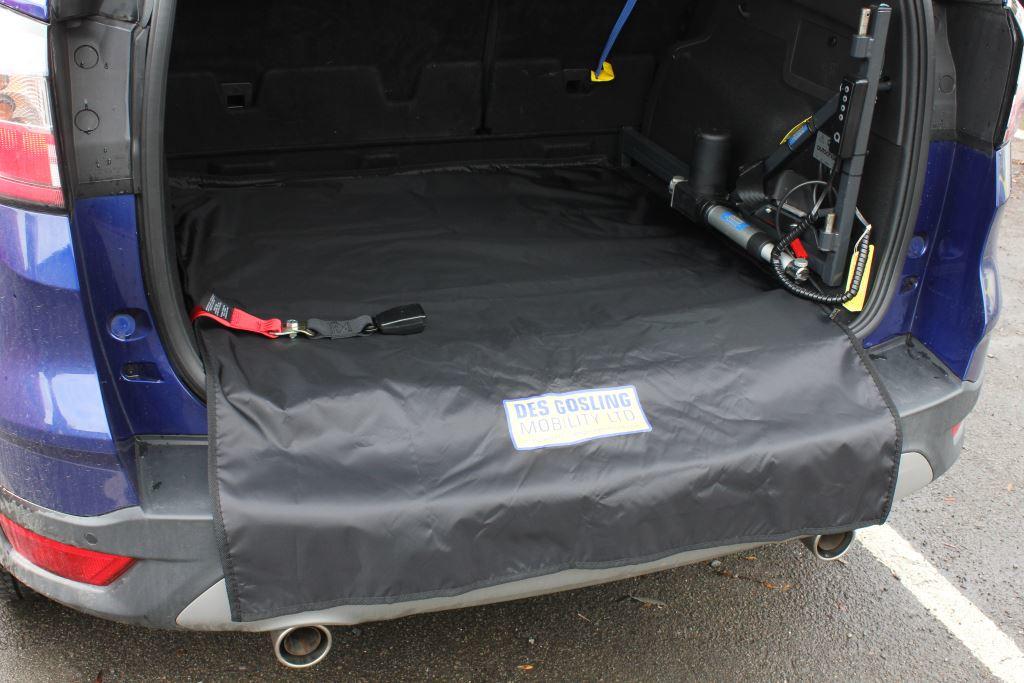 A large black rectangular fabric silk protector laid in the back of an open car boot with a hoist installed on the right side.
