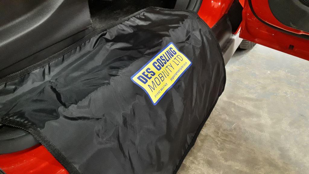 A black fabric sill protector is shown over the bottom of a car door frame.