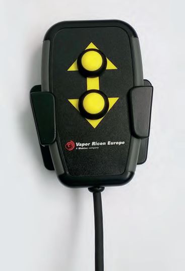 Wheelchair Winch Assist remote. A black handheld device with yellow buttons and a wire attached to the bottom, resting in a black plastic holder.