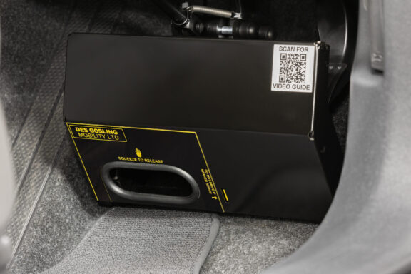 A black metal cover is installed over the car pedals.