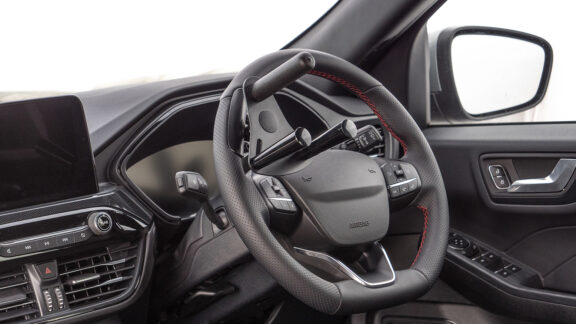 Steering aid with tetra grip option, three metal grips extend from the face of the steering aid.