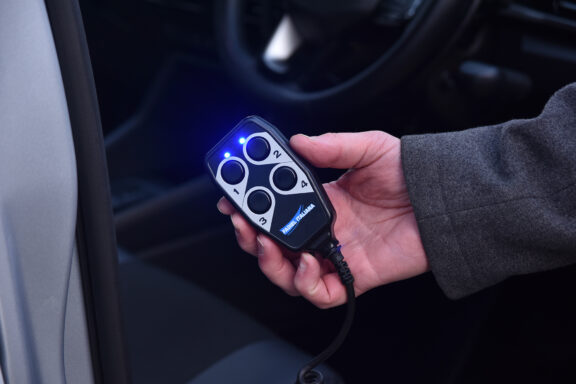 Close up of the E-Motion X wired remote, held in hand.