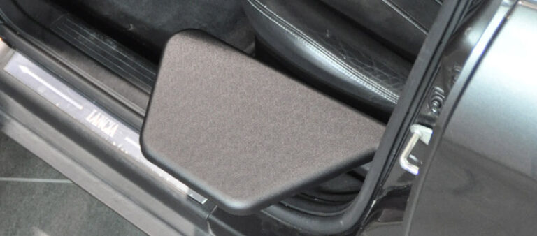 The tip up plate is shown unfolded in close up, as it extends into the open car door way.
