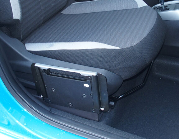 The foldable SEG Seat is shown folded down next to driver's seat. It is unobtrusive, and the top is roughly level with the level portion of the seat.