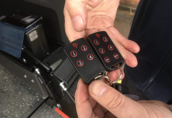 Close up of the remotes used to control the easy ramp. It has a black body with red outlined buttons.