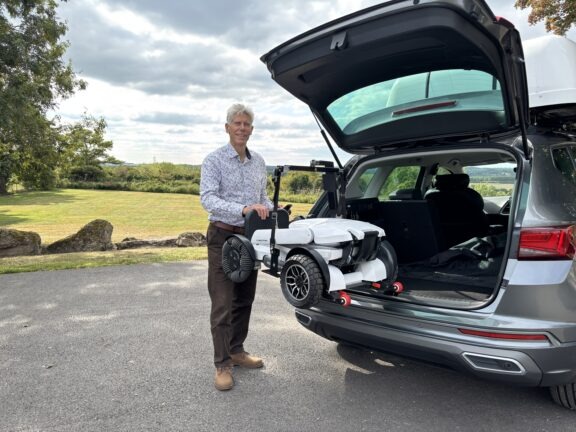 Des demonstrates operating a car mounted hoist
